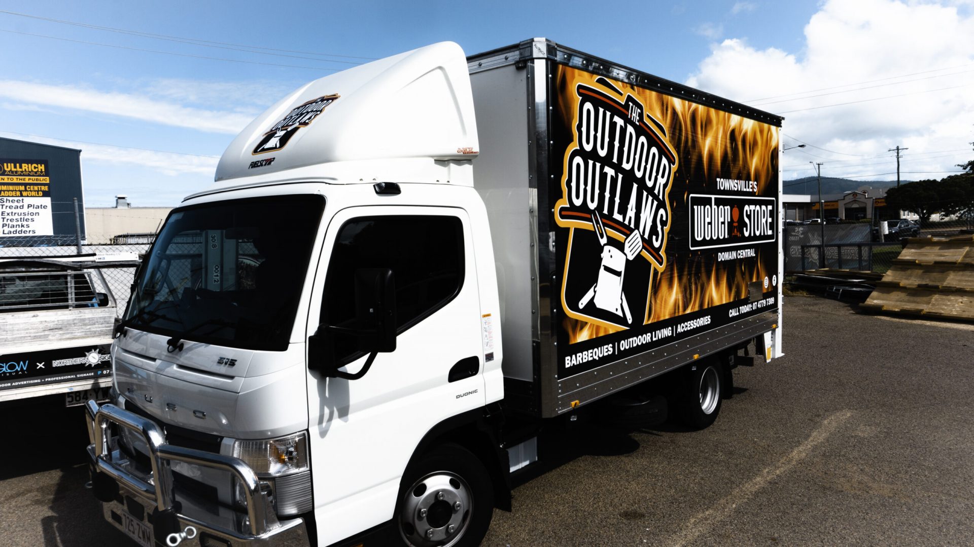 White van with partial car wrap showcasing business logos